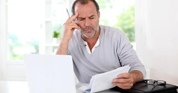 senior-man-puzzled-with-documents_573x300
